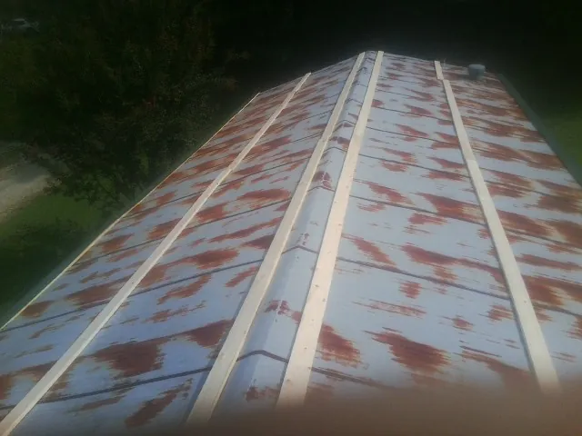 Rusted metal roof panels with new wood purlins before replacement — Storm Damage Roof Repair in Fraser by Roofing Brothers